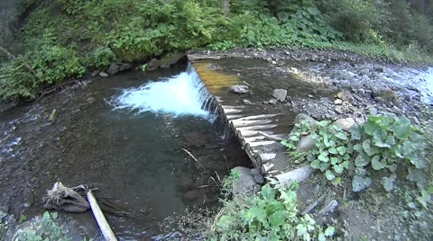 Tiny waterfall in small mountain river with green background Stock Footage 54308160