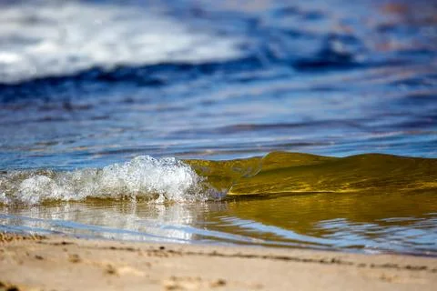 Tiny wave breaking on the beach Stock Photos