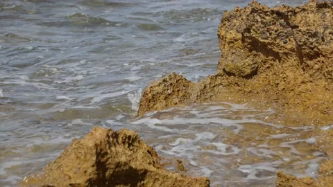 Tiny Wave jumping over a rocky beach 스톡 동영상 225654944