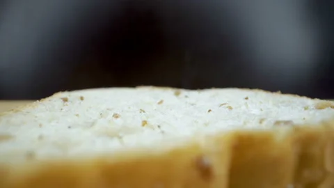 Tiny wheats on the sliced of bread on the table Stock Footage 135693322