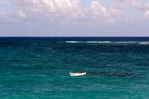 Tiny White Boat Alone on a Turquoise Ocean Stock Photos