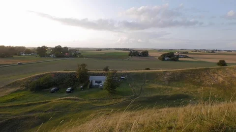 Tiny White Cottage Hidden Behind The Hills of Large Countryside Fields and 스톡 동영상 123518292