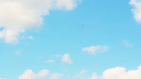 Tiny white private helicopter flies along boundless blue sky on warm sunny Stock Footage 221523013