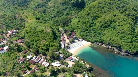 Tiny white sand Gesing beach by steep cliffs and remote village on Java Stock Footage 152815047