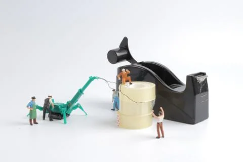 Tiny worker replace the tape for dispenser Stock Photos