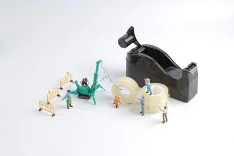 Tiny worker replace the tape for dispenser Foto stock