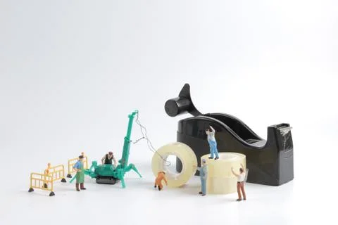 Tiny worker replace the tape for dispenser Foto stock