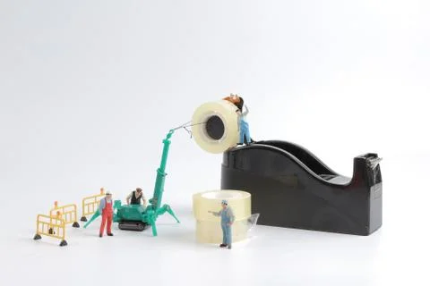 Tiny worker replace the tape for dispenser 스톡 사진
