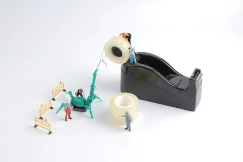 Tiny worker replace the tape for dispenser 스톡 사진