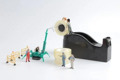 Tiny worker replace the tape for dispenser 写真素材