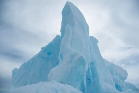 Tip of the iceberg on a background cloudy sky in the Antarctic winter day Stock Photos
