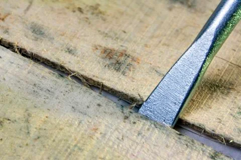 The tip of the mounting tool is inserted into the slot between the wooden boa Stock Photos