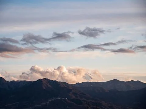 The tip of Mt. Fuji surrounded by clouds in the evening Stock Photos