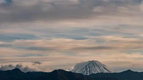 The tip of Mt. Fuji surrounded by clouds in the evening Stock Photos