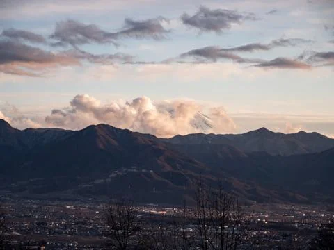 The tip of Mt. Fuji surrounded by clouds in the evening Foto stock
