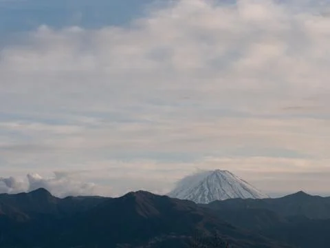 The tip of Mt. Fuji surrounded by clouds in the evening Stock-Fotos