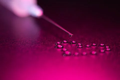 The tip of the syringe with a drop, drops in the shape of a heart Foto stock