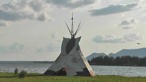 Tipi on the river bank, at dusk and crows flying around Stock-Footage 166330972