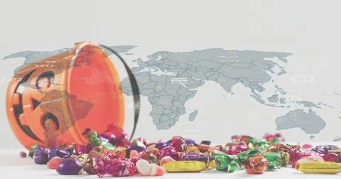 Tipping orange jack-o-lantern bucket, spilling colorful candies across white Stock Photos