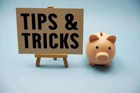 Tips And Tricks text and piggy bank for saving on blue background Stock Photos
