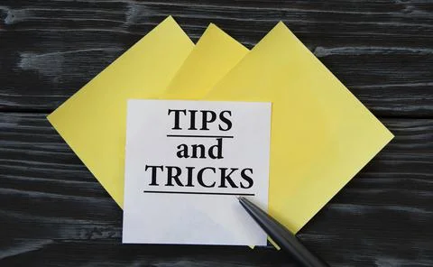 TIPS and TRICKS - words on note paper on a black background Stock Photos