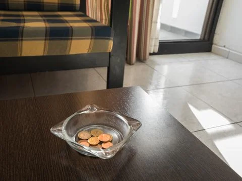 Tips in the ashtray on a hotel table Stock Photos