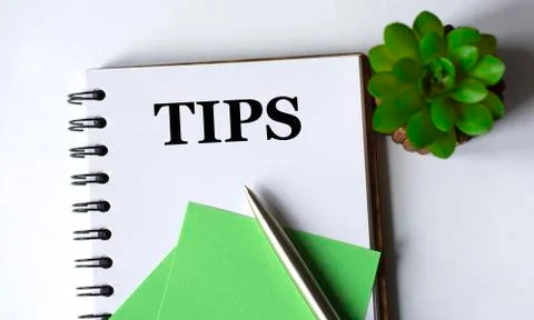 TIPS - word in a notebook with a pen, a green paper and a cactus on a white b Stock Photos