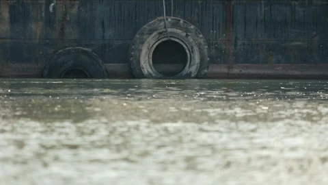 Tire bumpers on side of barge in a river Stock Footage 278529293