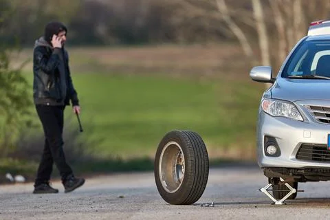 Tire change problems on the road, phona call for help Fotos Stock