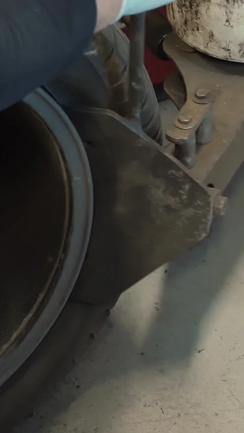 Tire Fitting. Mechanic using hydraulic or mechanical press to remove used tire Stock Footage 314565477