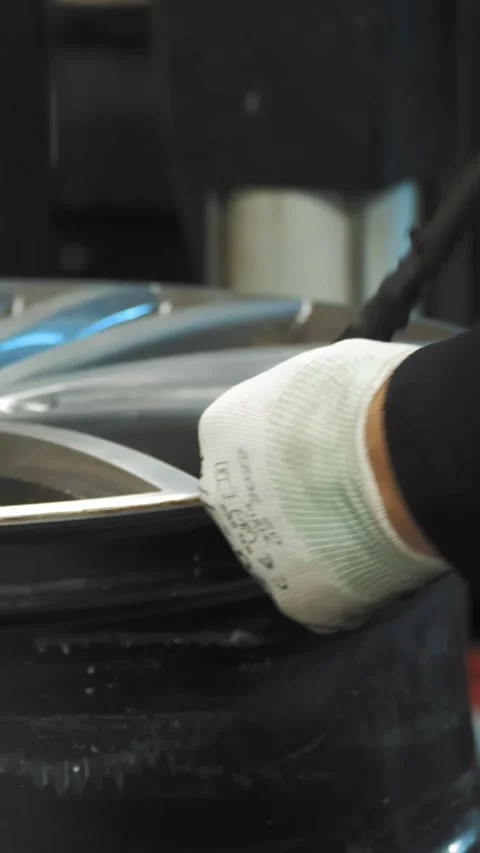 Tire Fitting. Mechanic using hydraulic or mechanical press to remove used tire Stock Footage 314660037
