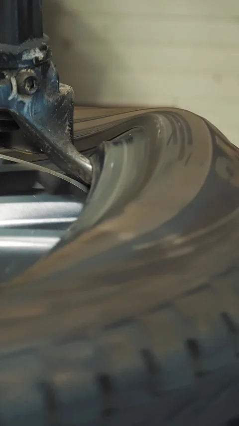 Tire Fitting. Mechanic using hydraulic or mechanical press to remove used tire Stock Footage 314889763
