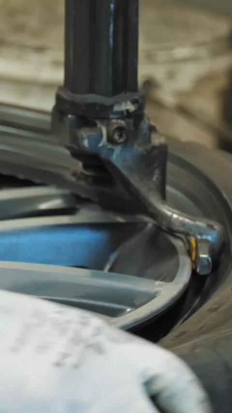 Tire Fitting. Mechanic using hydraulic or mechanical press to remove used tire Stock Footage 314889827