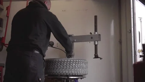 Tire fitting. Service man put on tyre on car wheel by petrol explosion. Bright 스톡 동영상 142998643