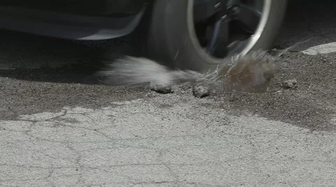 Tire Hits Puddle Pothole in Slow Motion Medium Shot Stock Footage 65730510