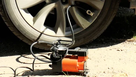 Tire inflation by car compressor Stock Footage 79850460