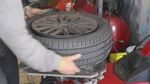 Tire mechanic changing a wheel in mechanical workshop. Stock Footage 130585992