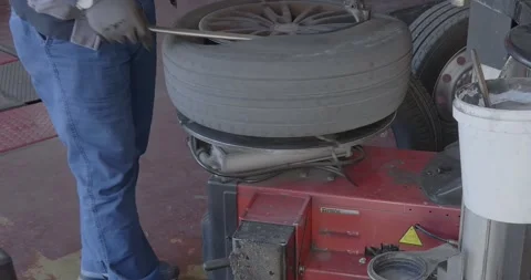 Tire mechanic changing a wheel in mechanical workshop. Vidéo 221089688
