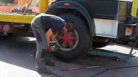 Tire repairer at work that changes and repairs truck and car tires in the garage Stock Footage 115988396