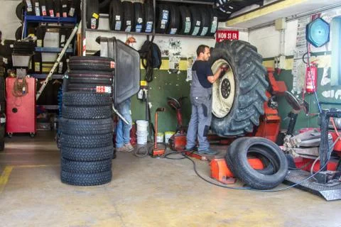 Tire repairer at work that changes and repairs truck and car tires in the garage Stock-Fotos