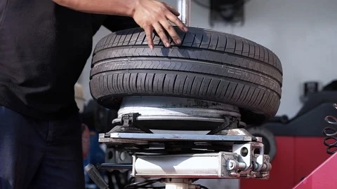 Tire Replacement concept. Mechanic Working his Job with Wheel in Garage. Car Stock Footage 103805189