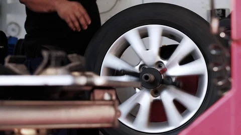 Tire Replacement concept. Mechanic Working his Job with Wheel in Garage. Car Stock Footage 104245589