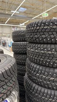 Tire stacks in store showcasing winter tires with visible treads and spikes.. 스톡 사진