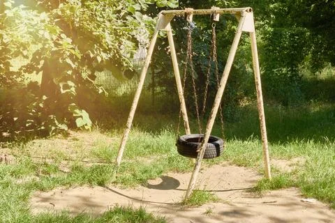 Tire swing hanging on chains. Old metal playground swing. Homemade tire swi.. Foto stock