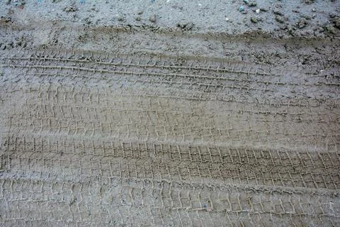 Tire tracks creating a textured pattern on mud ground Stock Photos