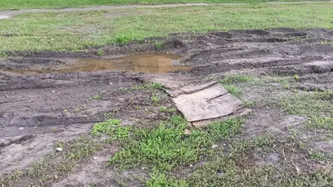 Tire tracks on the grass that turned to mud after the rain. Puddle on the road Stock Footage 317669436