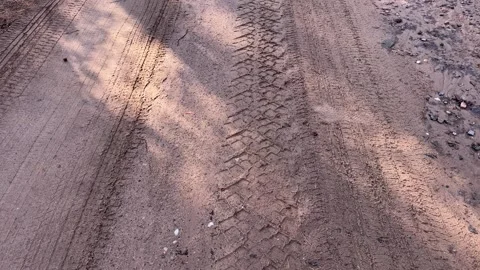 Tire tracks on a sandy dirt road with tree shadows Vidéo 339723905