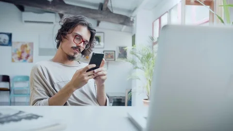 Tired and bored of work study hipster chatting by mobile app or social network Stock Footage 98897008
