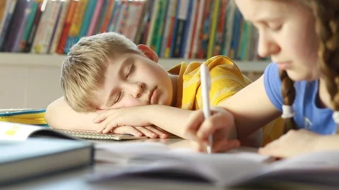 Tired and exhausted   primary school student falling asleep while studying Stock Footage 87611546