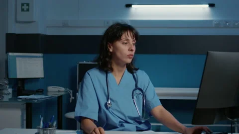 Tired assistant working over hours in hospital office analyzing patient disease Stock Footage 224392941